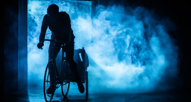 Josh St. Clair as Gino Bartali, seen in shadow riding a bike
